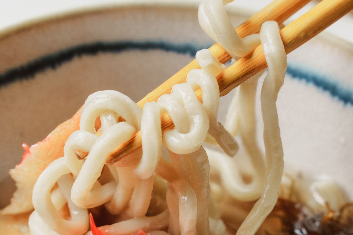 三枚肉そば。自家製麺を箸で持ち上げたところ