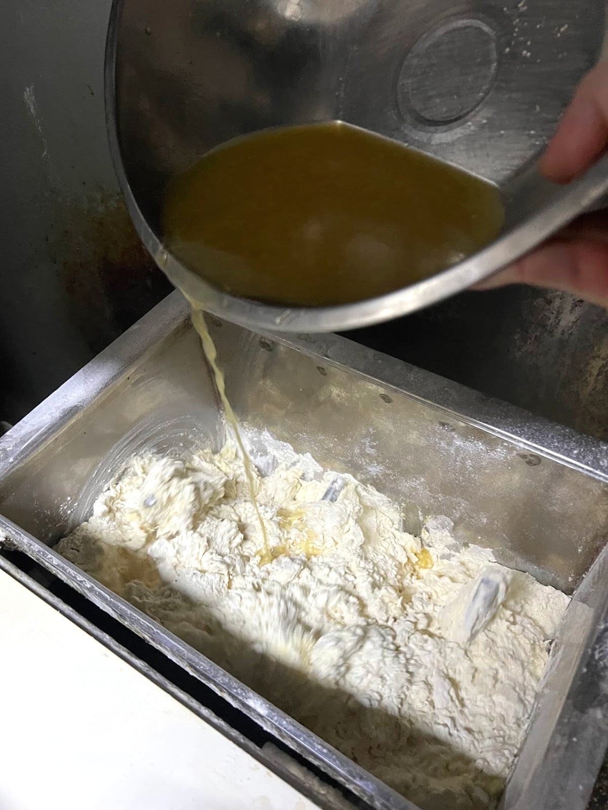 製麺用の粉へ出汁を注ぐ様子